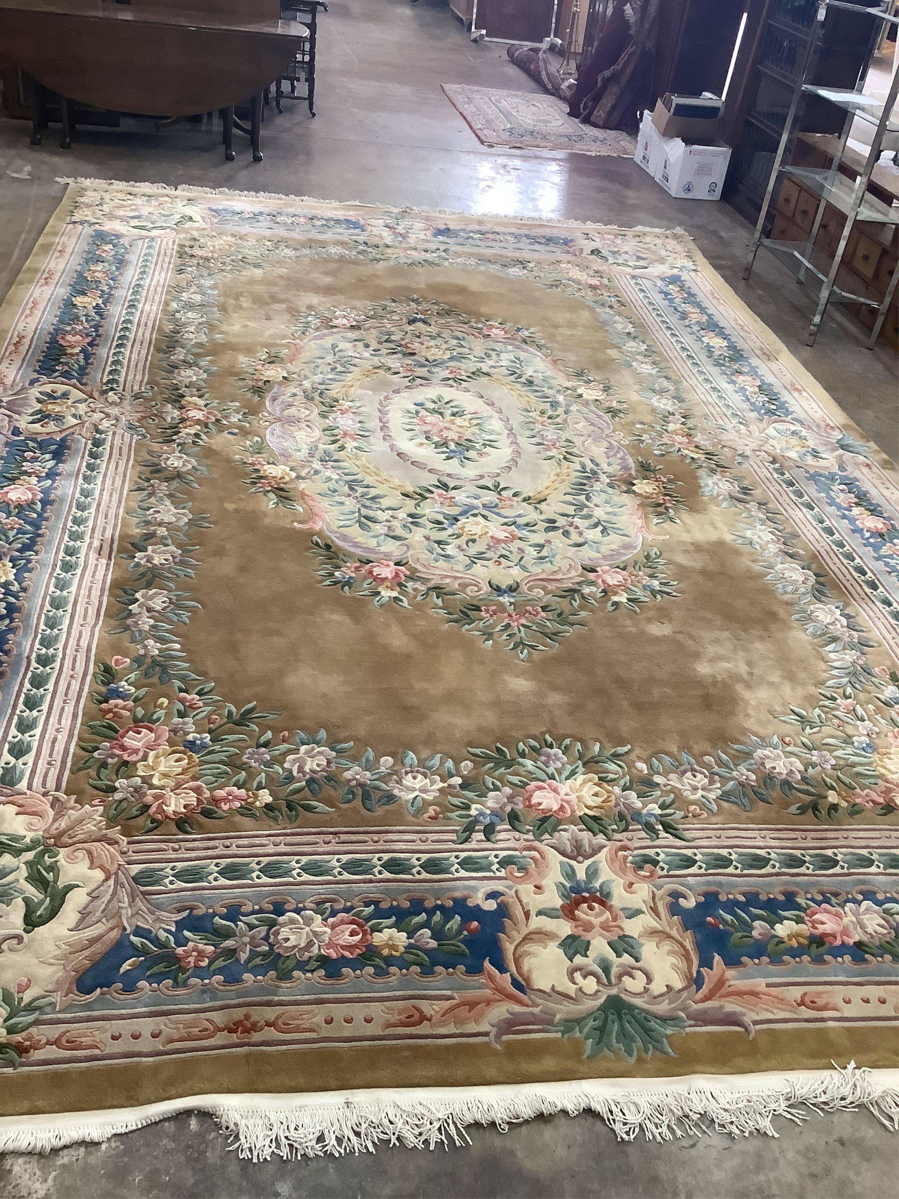 A large Chinese washed woollen gold ground floral embossed carpet, 560cm x 370cm. Condition - good